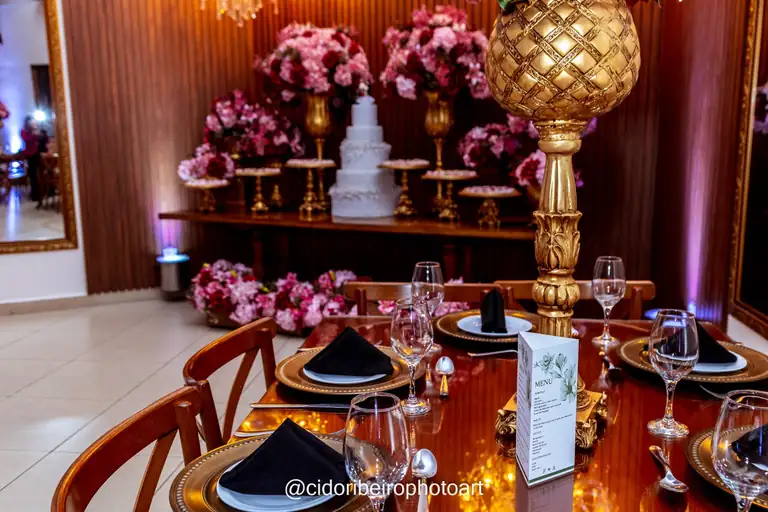 Mesa posta com decoração dourada e flores no Espaço Montello
